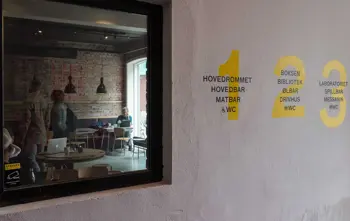 Vegg med informasjon om etasjene og et vindu inn til kaféen på Kulturhuset i Oslo