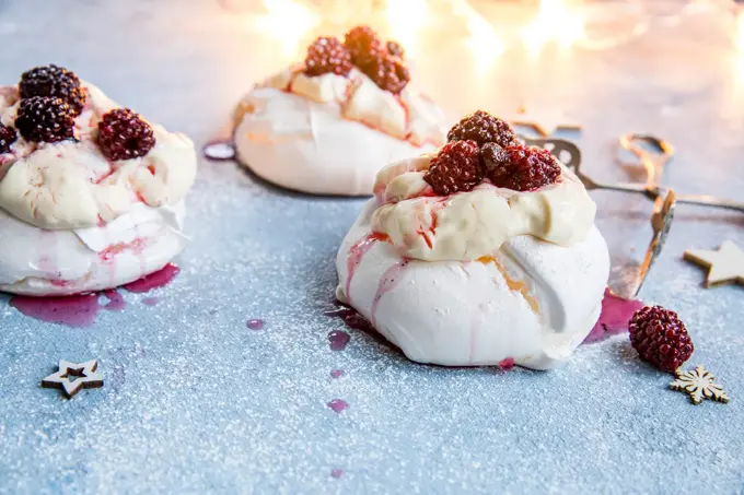 3 minipavlovaer med krem og bær på toppen