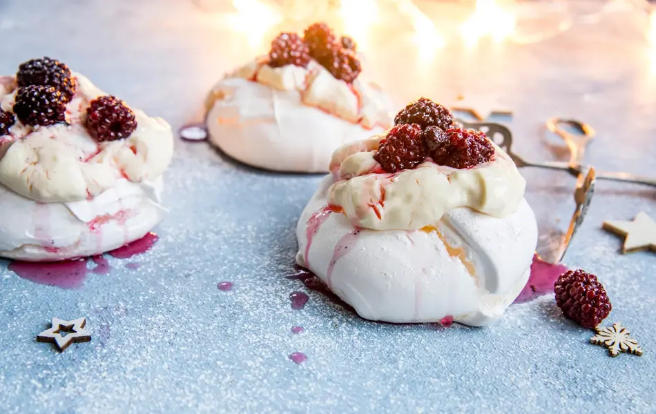 3 minipavlovaer med krem og bær på toppen