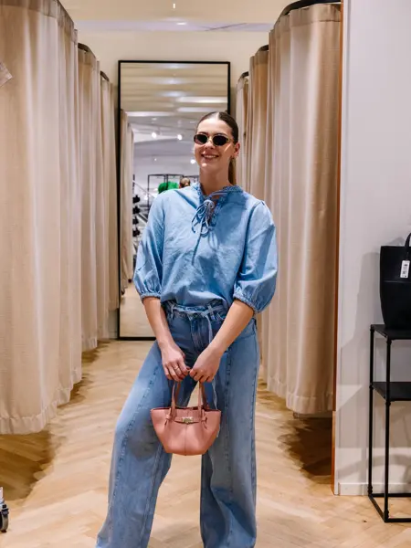 dame i vårklær står ved prøverom