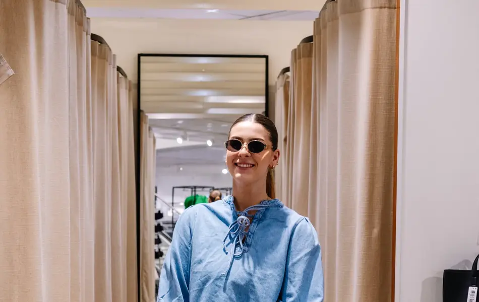 dame i vårklær står ved prøverom