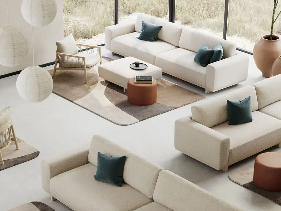 Rom med store vinduer dekorert med diverse hvite sofa, puffer, stuebord, tepper og lampe