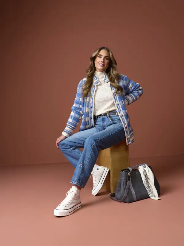Tone i hvit t-skjorte, rutete skjorte, jeans, converse og stor veske.