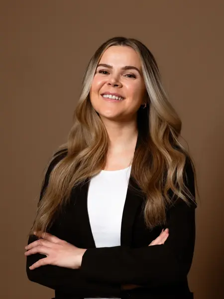 Mørkhåret dame med sort jakke og hvit topp