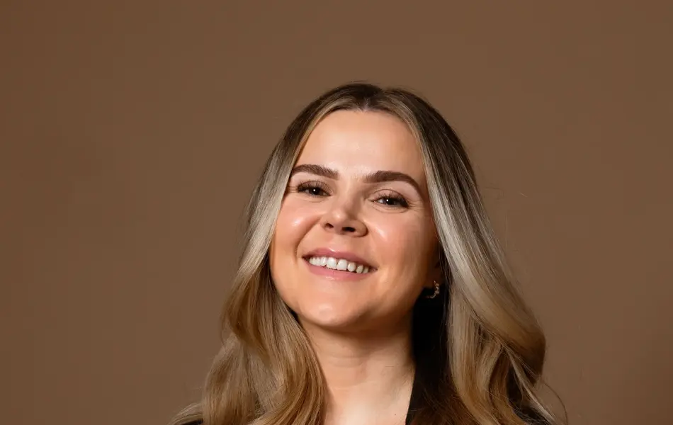 Mørkhåret dame med sort jakke og hvit topp