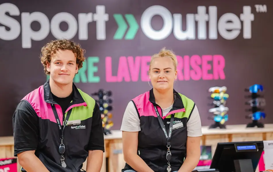 To som smiler til kamera med Sport Outlet logoen i bakgrunn