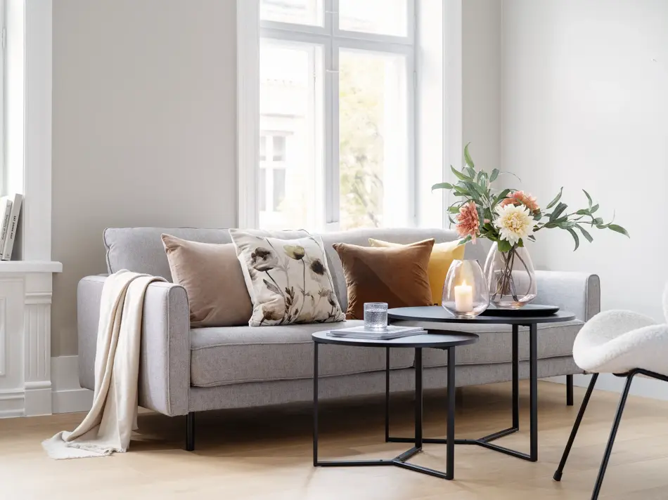 Sofa med puter og tildekket stuebord