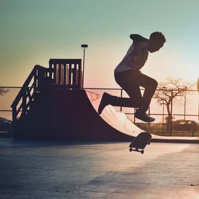 Mann skater på skateboard i skatepark