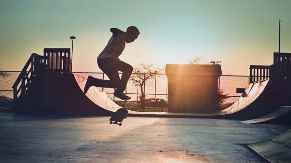 Mann skater på skateboard i skatepark