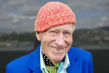 Et fotografi av Olav Thon, med sin signatur-lue på