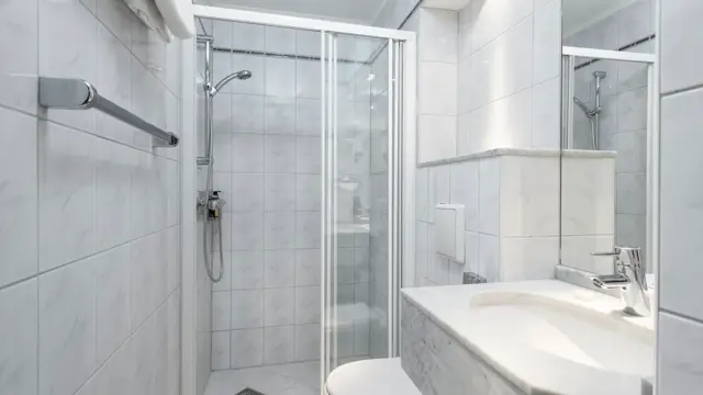 Bad med dusj, vask og toalett på Standard singelrom på Hotel Bristol i Oslo sentrum