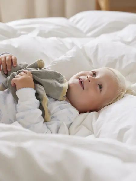 Gutt som ligger i en seng