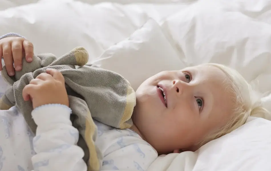 Gutt som ligger i en seng