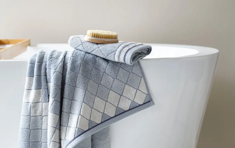 Produkter fra Princess. Blått og hvitt håndkle som henger over badekar.