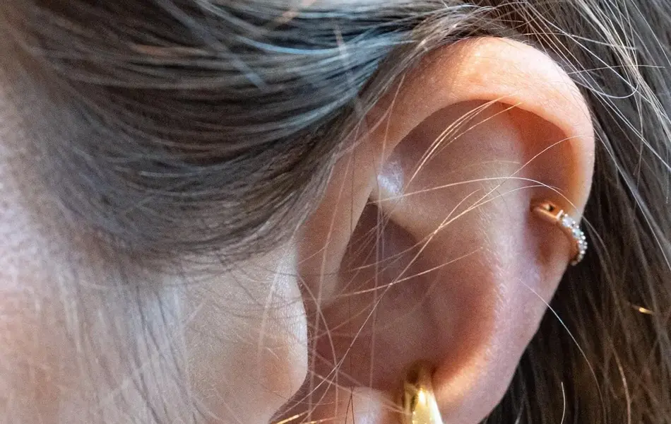 Nærbilde av øre med flere øredobber