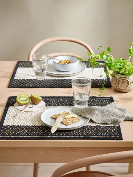 pådekket bord med mørk og lyse spisebrikker