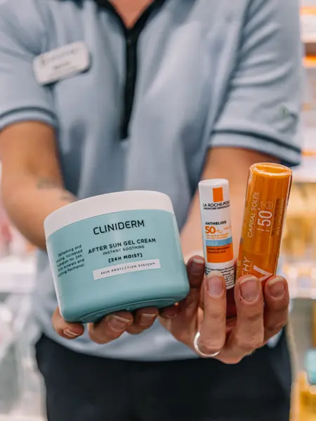 Dame som holder frem solkrem