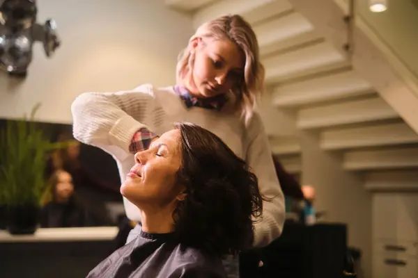 dame får stylet håret sitt ho frisør