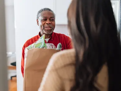 Mann som mottar en pose med mat