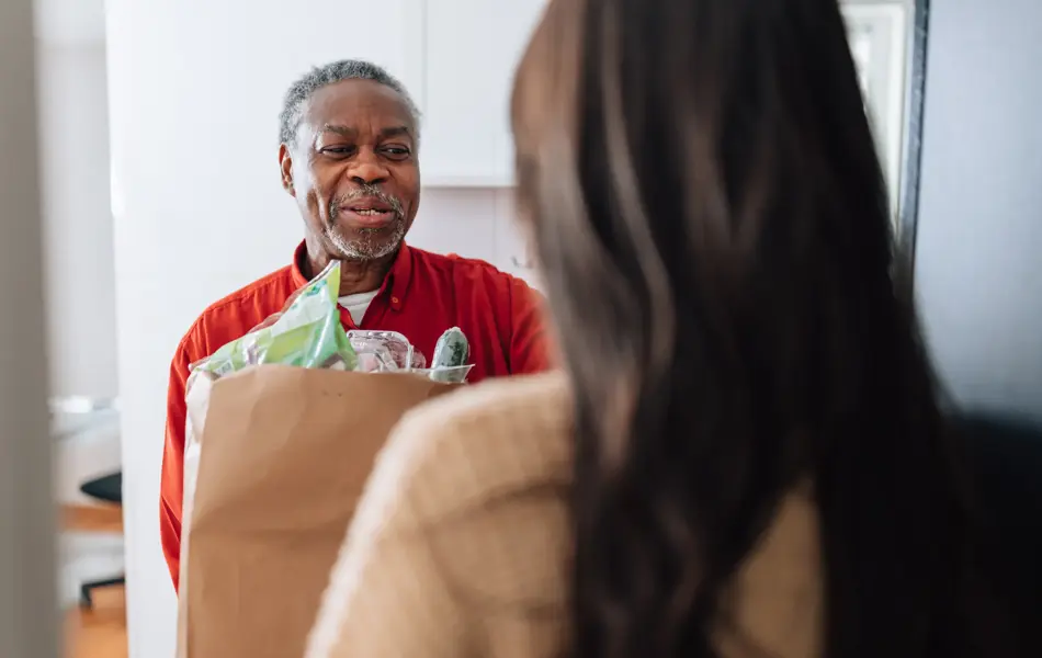 Mann som mottar en pose med mat