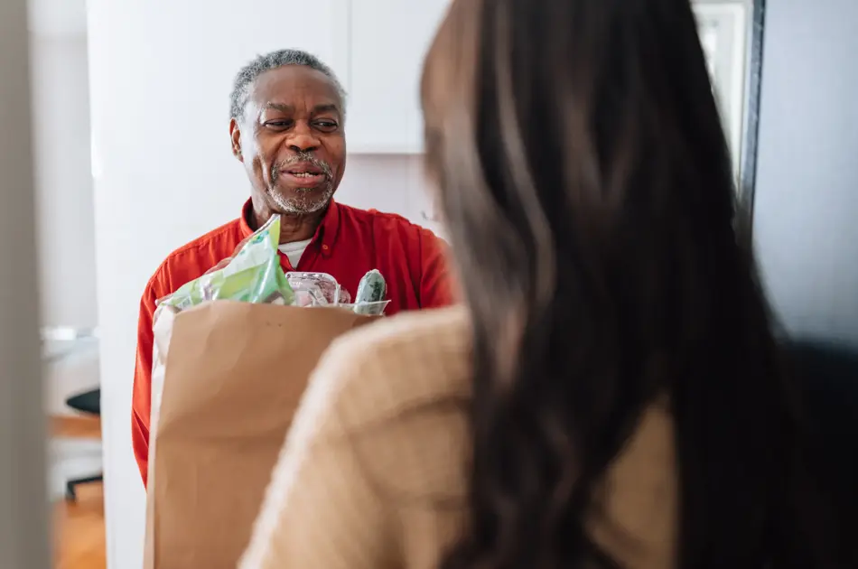 Mann som mottar en pose med mat