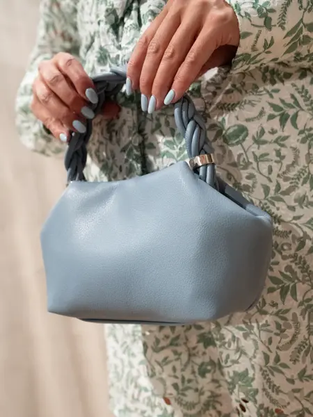Dame holder liten lyseblå veske