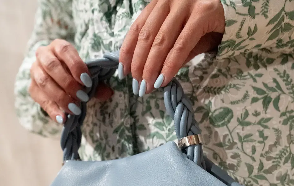 Dame holder liten lyseblå veske