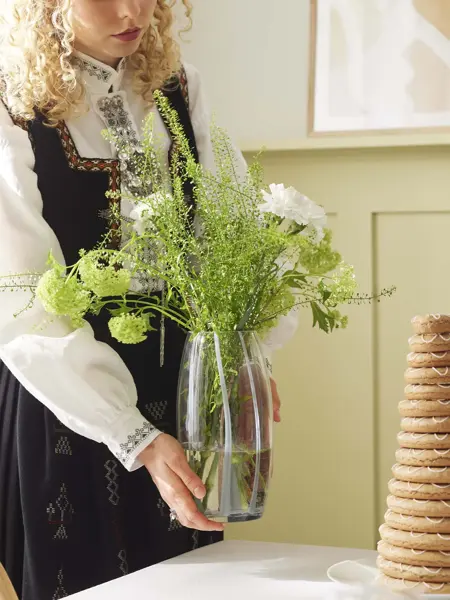 Dame som holder en vase med blomster