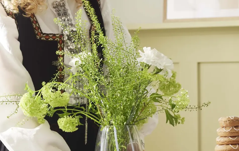 Dame som holder en vase med blomster