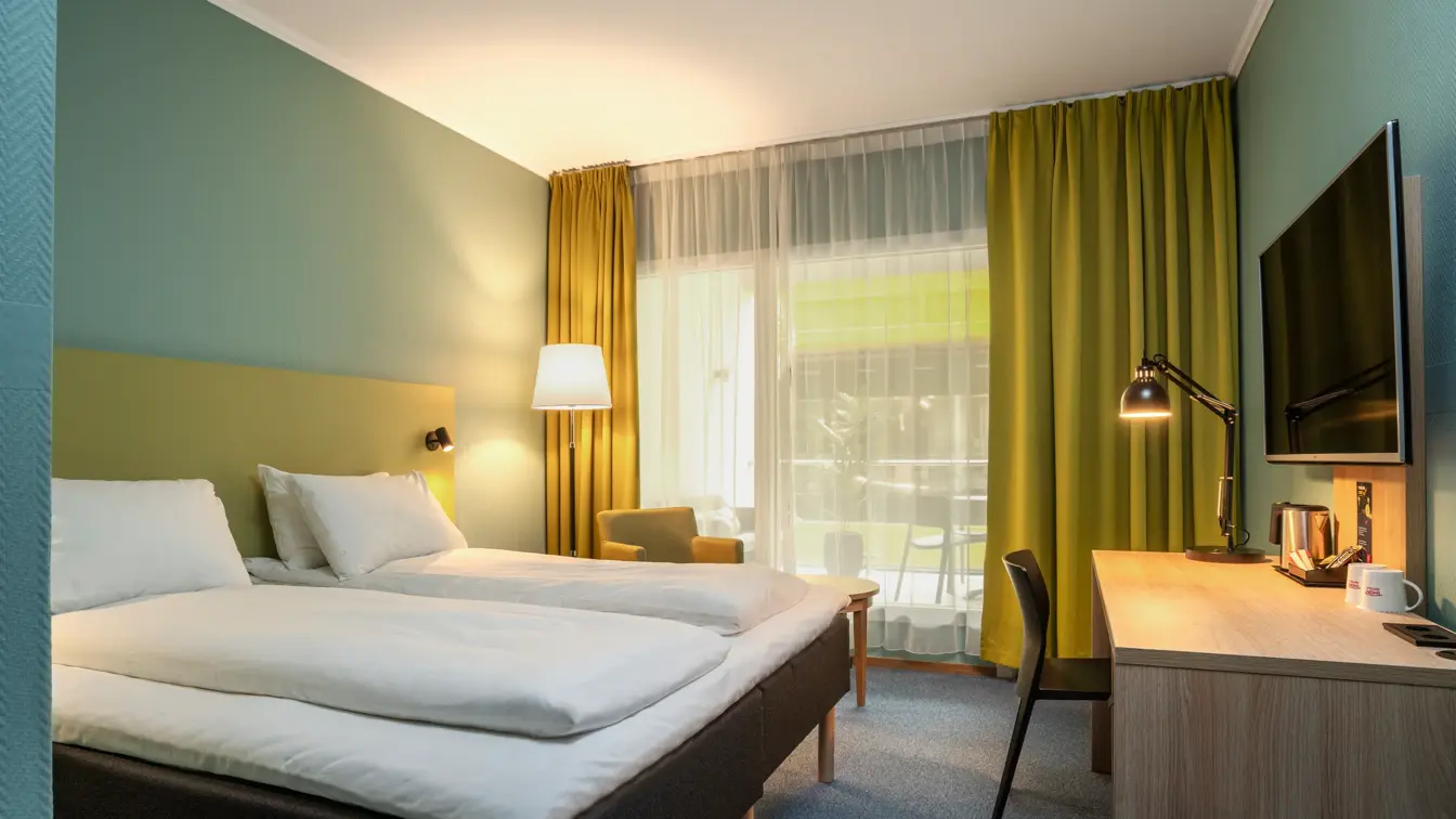 Vindu, gule gardiner, to turkise lenestoler, skrivebord, speil, twin beds, gul stol, turkise vegger