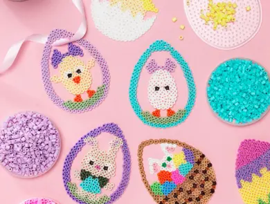 Ulike perle påskeegg ligger på et bord med rosa duk