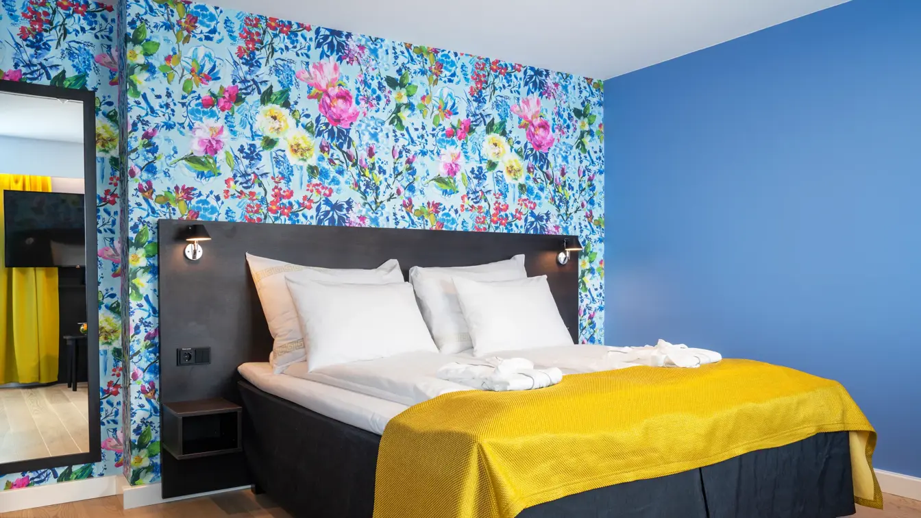 Dobbeltseng, blomstrete tapet og speil i superior rom på Thon Hotel Moldefjord