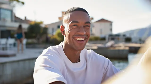 Nærbilde av smilende mann med hvit t-skjorte  