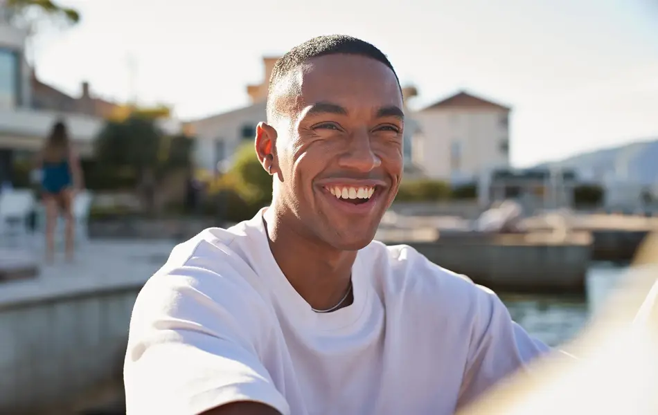 Nærbilde av smilende mann med hvit t-skjorte  