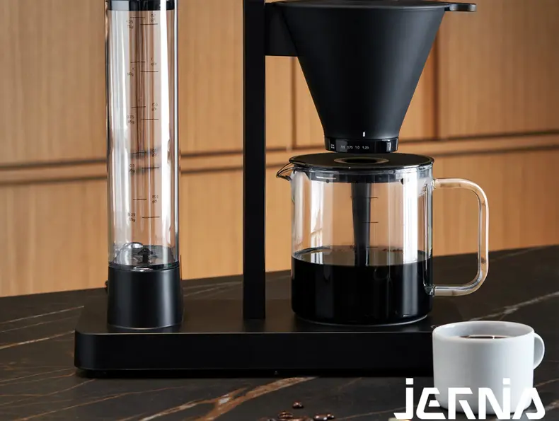 Sort kaffetrakter med glasskanne og kaffekopp.