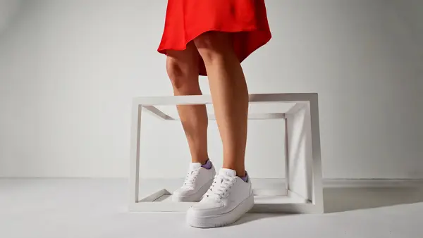 dame med rødt skjørt og hvite sneakers