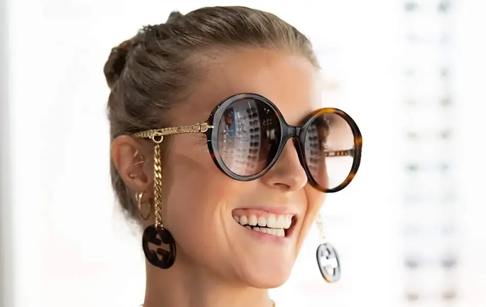 Ung kvinne iført store, runde solbriller