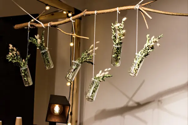 decorative bouquets suspended to a wooden branch. modern decor. a modern bouquet of greens and spikelets.