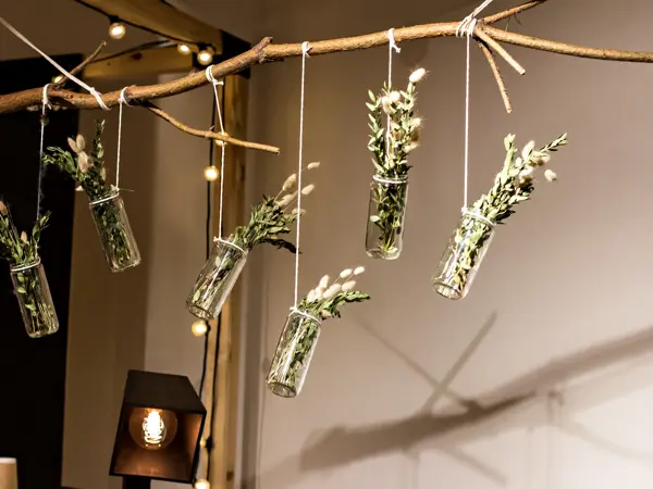 decorative bouquets suspended to a wooden branch. modern decor. a modern bouquet of greens and spikelets.