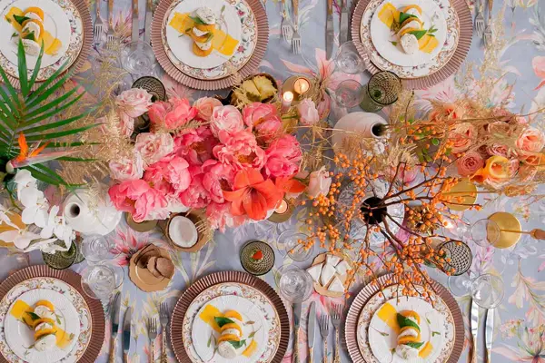 Oversiktbilde av bord dekket med fargerike blomster og tallerkener til 6 stykker