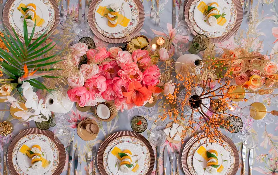 Oversiktbilde av bord dekket med fargerike blomster og tallerkener til 6 stykker