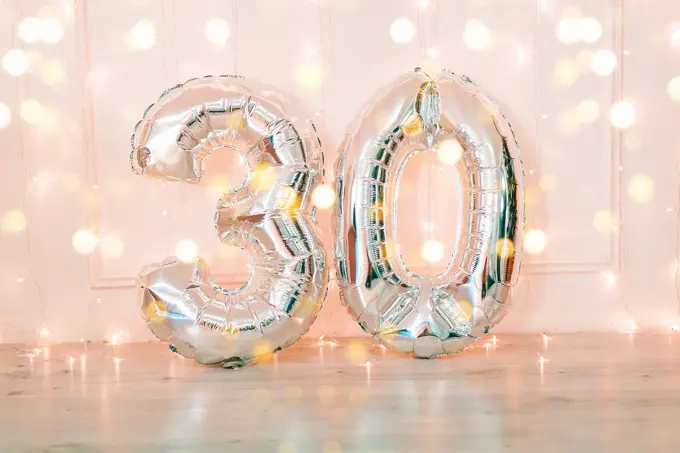Silver foil birthday balloons number 30 with glitter lights. Birthday concept.