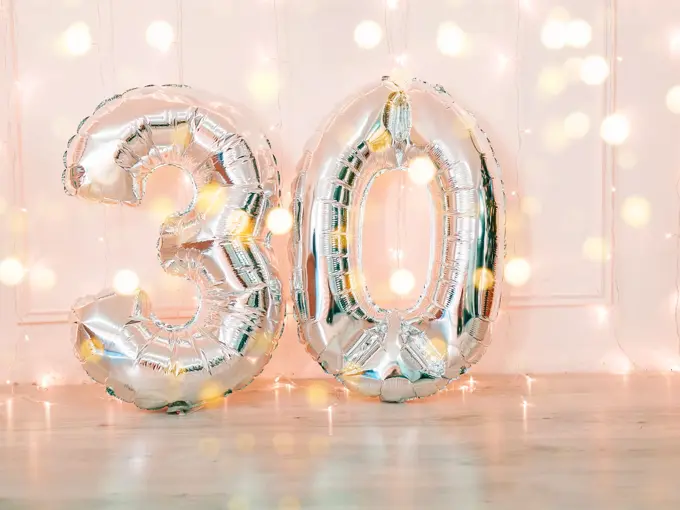 Silver foil birthday balloons number 30 with glitter lights. Birthday concept.
