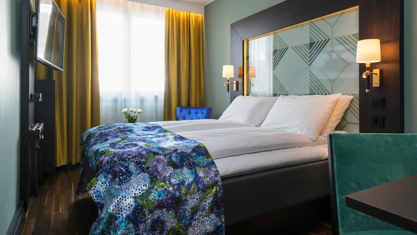 Dobbeltseng med stol og smart-TV på Thon Hotel Orion i Bergen sentrum