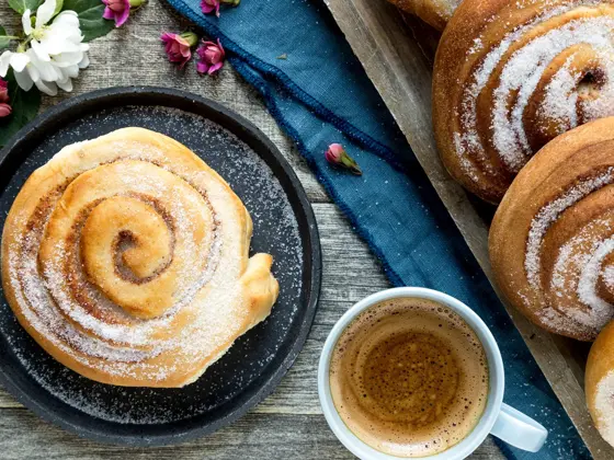 Miljøbilde av skillingsboller og en kopp kaffe