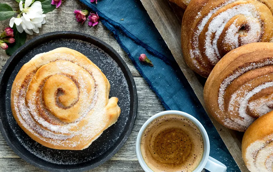 Miljøbilde av skillingsboller og en kopp kaffe