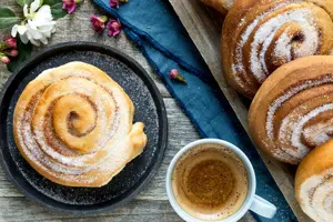 Miljøbilde av skillingsboller og en kopp kaffe