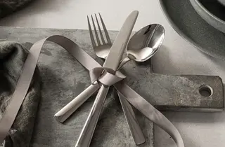 Bestikk i rustfritt stål bundet sammen med et bånd.