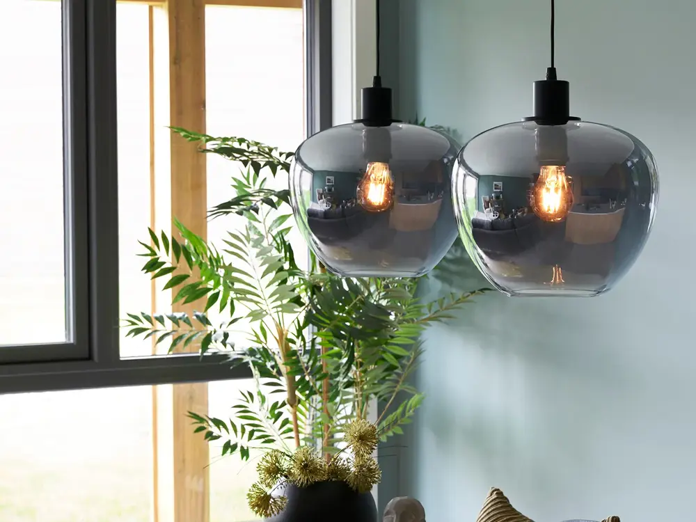 Lampe henger fra taket med maleri i bakgrunn 