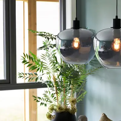 Lampe henger fra taket med maleri i bakgrunn 